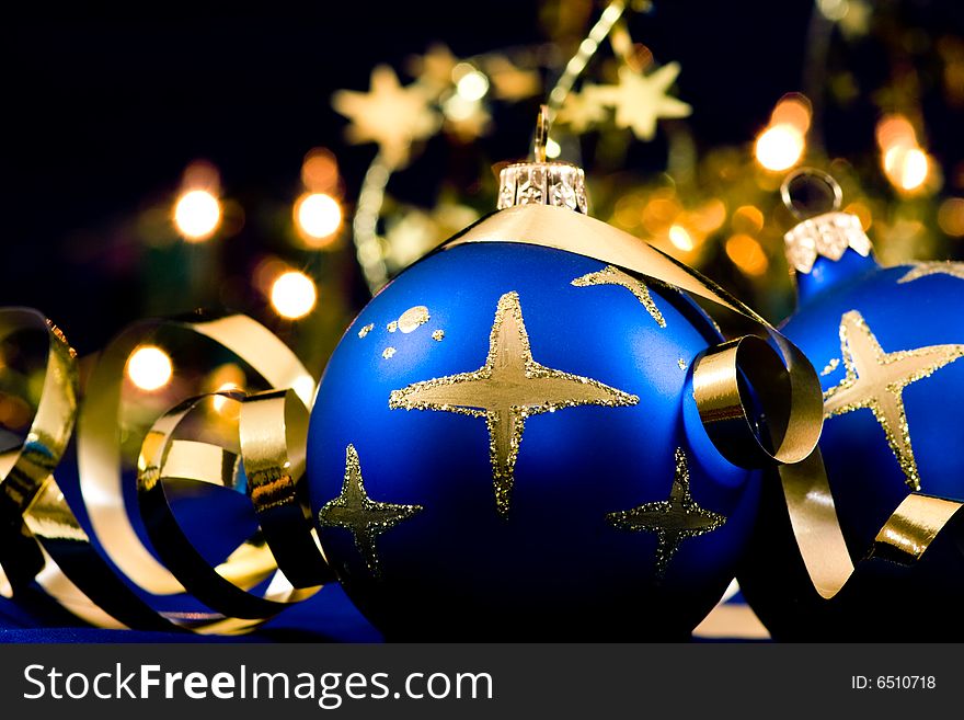 Christmas blue baubles with blurred lights in background, selective focus. Christmas blue baubles with blurred lights in background, selective focus