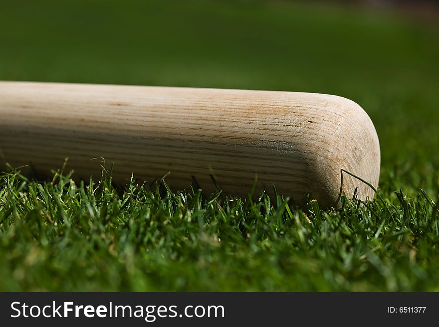 Baseball bat on the green grass of a ball field
