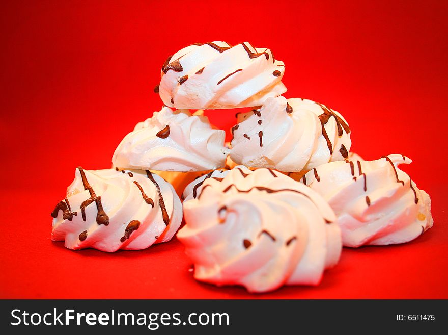 Pyramid of white meringues on a red background. Pyramid of white meringues on a red background