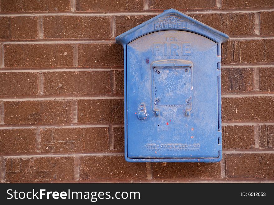 Old blue fire pull station on brick wall. Old blue fire pull station on brick wall
