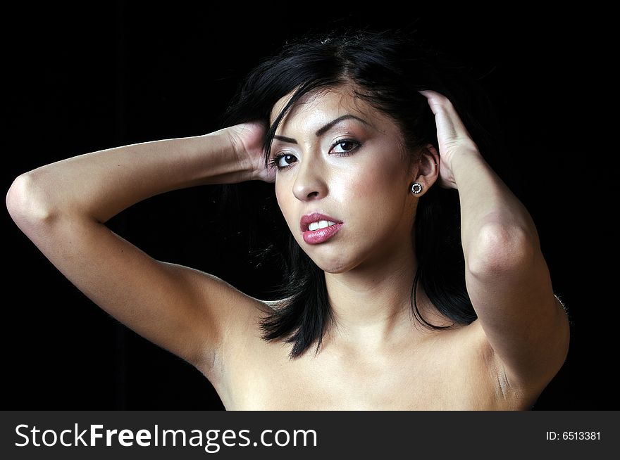 Beautiful young Hispanic brunette woman adjusting hair. Beautiful young Hispanic brunette woman adjusting hair