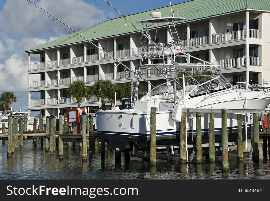 Luxury sailboat parked in a boat slip next to condos in a tourist area. Luxury sailboat parked in a boat slip next to condos in a tourist area.