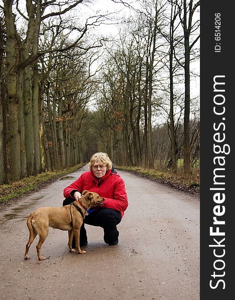 Elderly woman together with the dog in a park