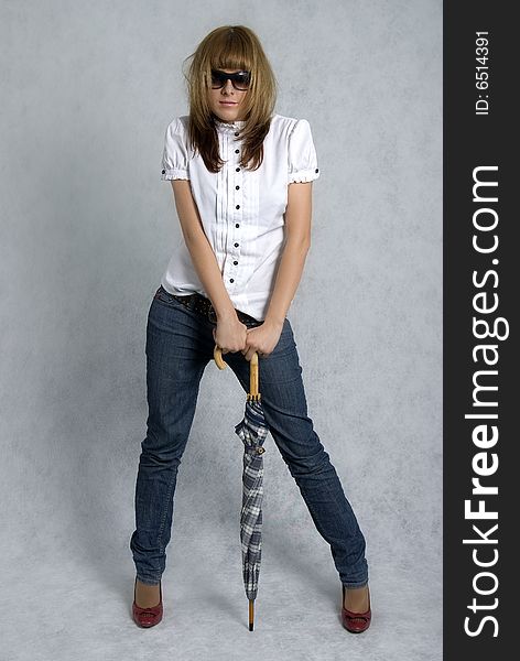 Stylish girl in white blouse and blue jeans with umbrella