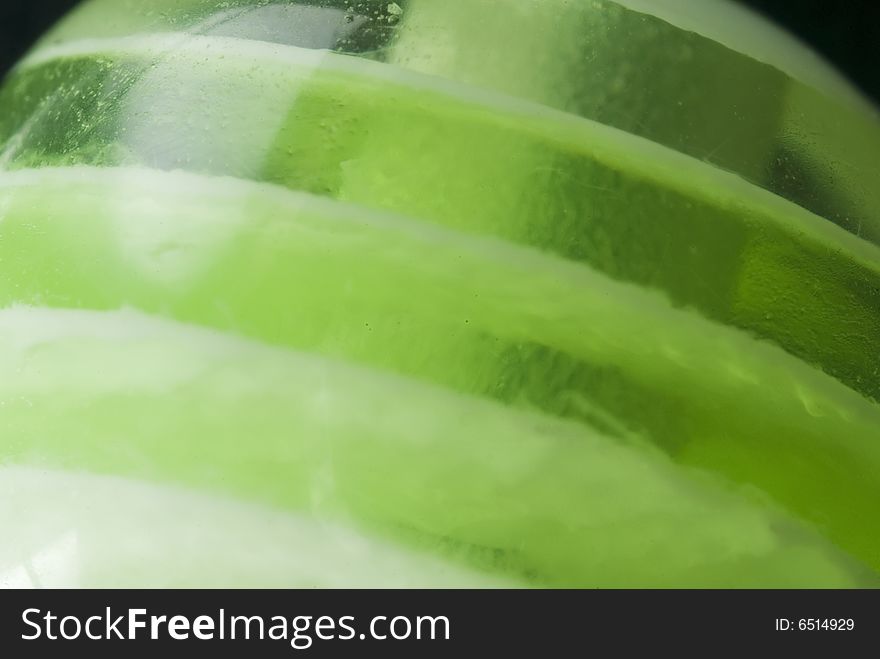 A close up shot of a green glass marble. A close up shot of a green glass marble