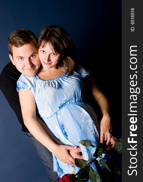 Young pregnant woman and her husband embracing