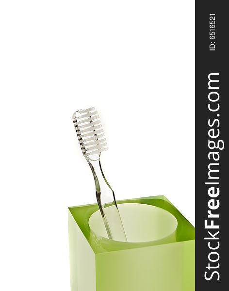Toothbrushes in glass on a white background