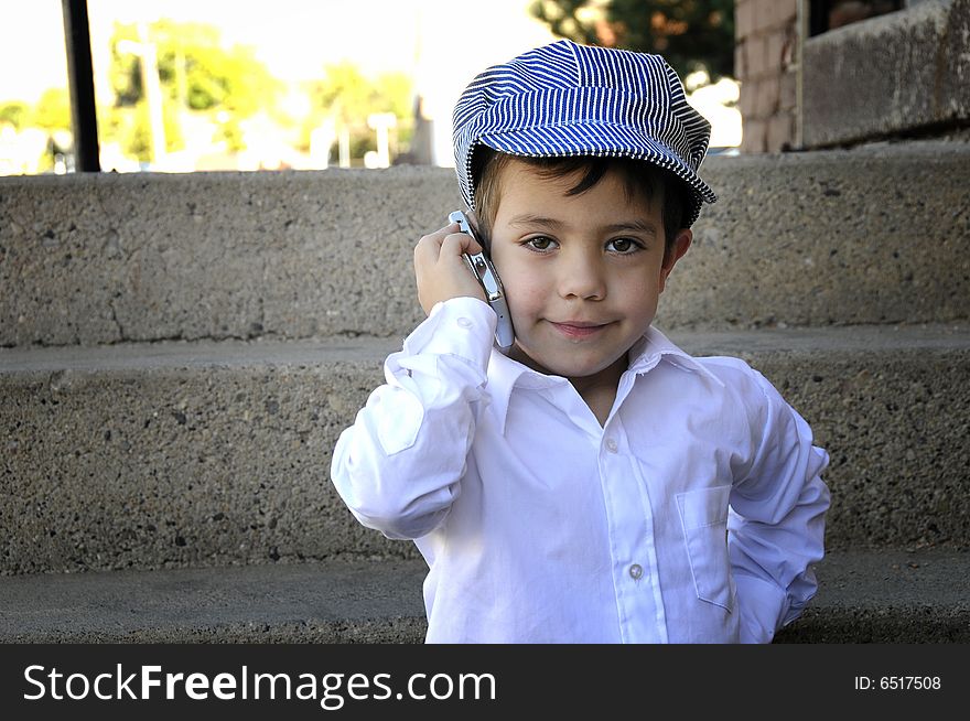 Young boy talking on the phone in the street