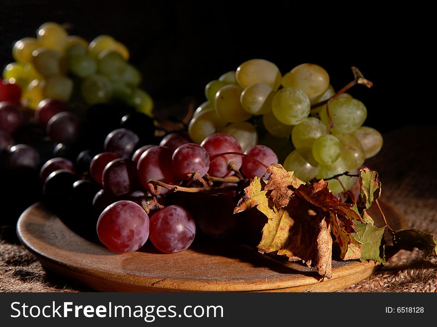 Grapes in wooden cup on burlap background