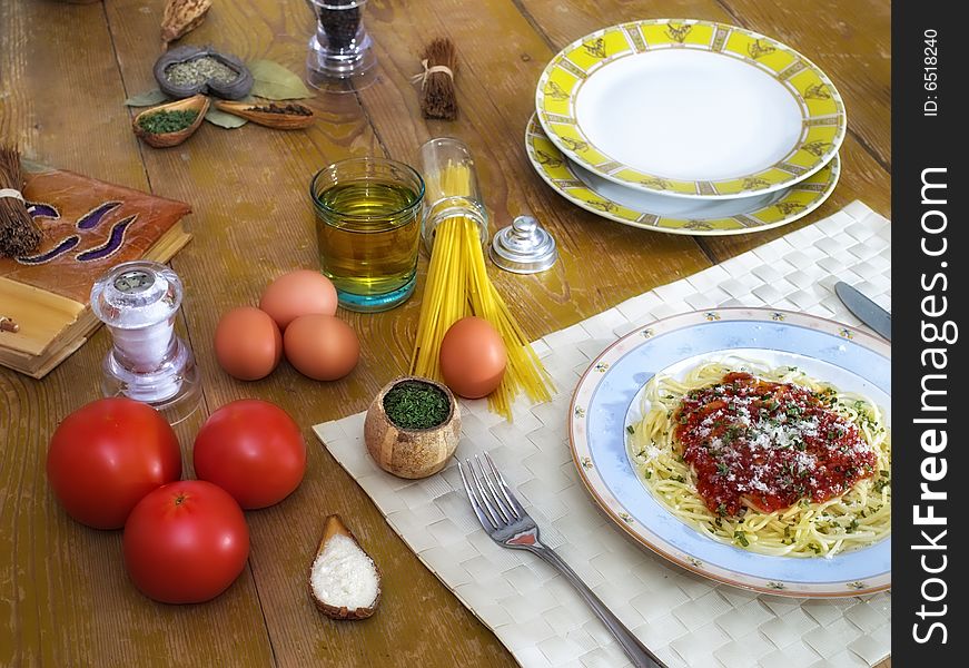 Spaghetti and tomato sauce on wooden desk