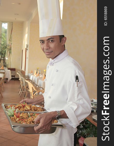 Chef carrying food on chafing dish for buffet. Chef carrying food on chafing dish for buffet