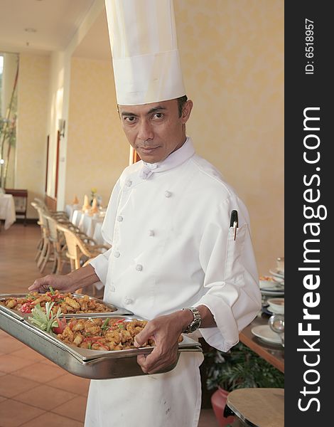 Chef carrying food on chafing dish for buffet. Chef carrying food on chafing dish for buffet