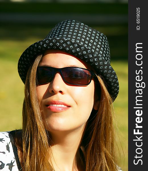 A beautiful girl with a hat enjoying the sunny weather