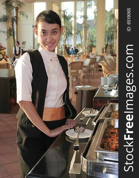 The beautiful waitress smiling at buffet restaurant