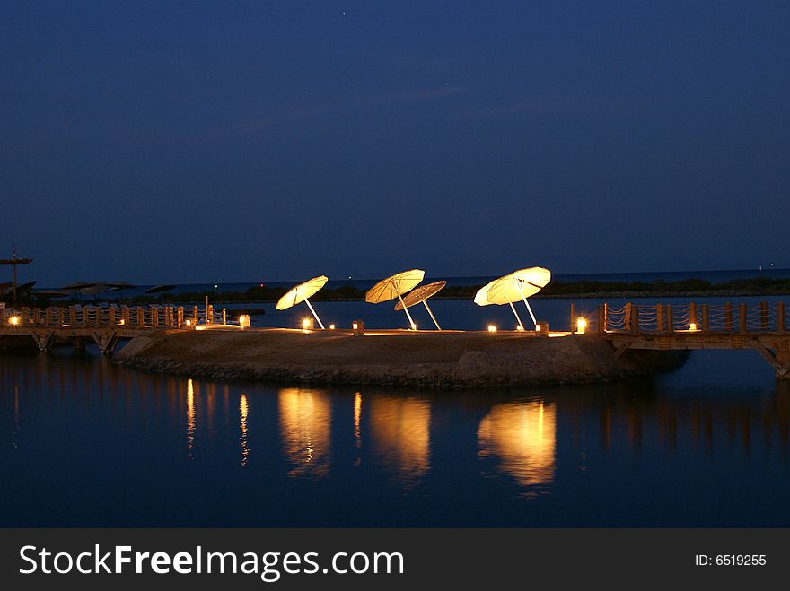 Night pier with umbrellas in Egypt.