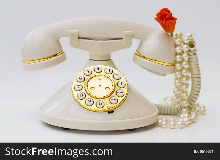 Vintage phone with pearls and red flower