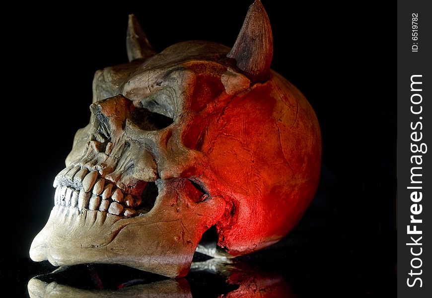 Spooky Devil Skull With shot with red-white light. Spooky Devil Skull With shot with red-white light