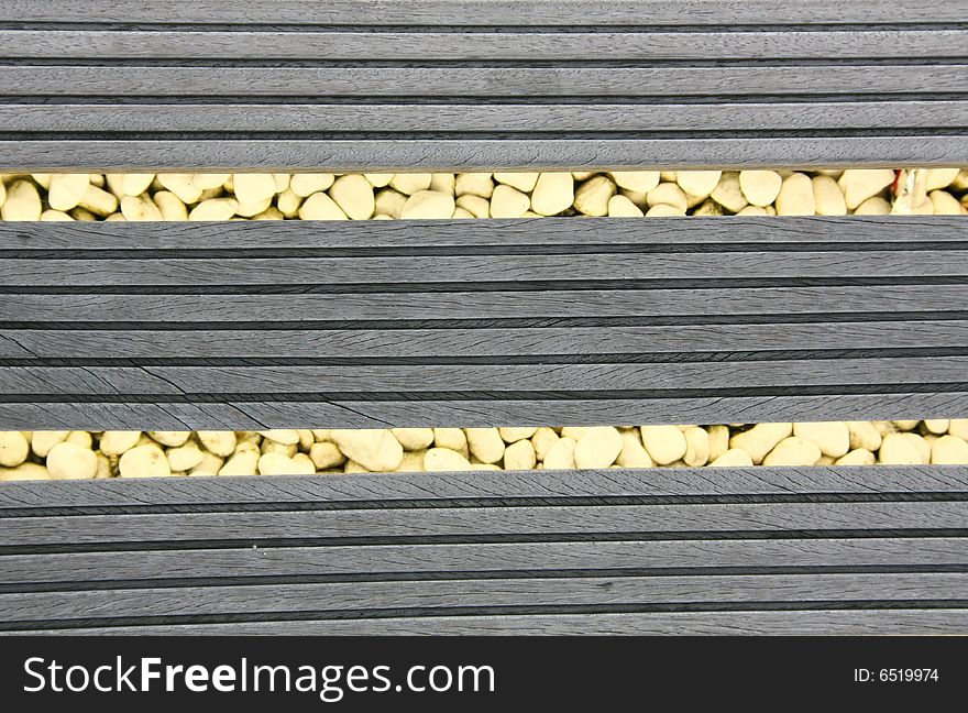 Grey wooden border upon lightened stones. Grey wooden border upon lightened stones