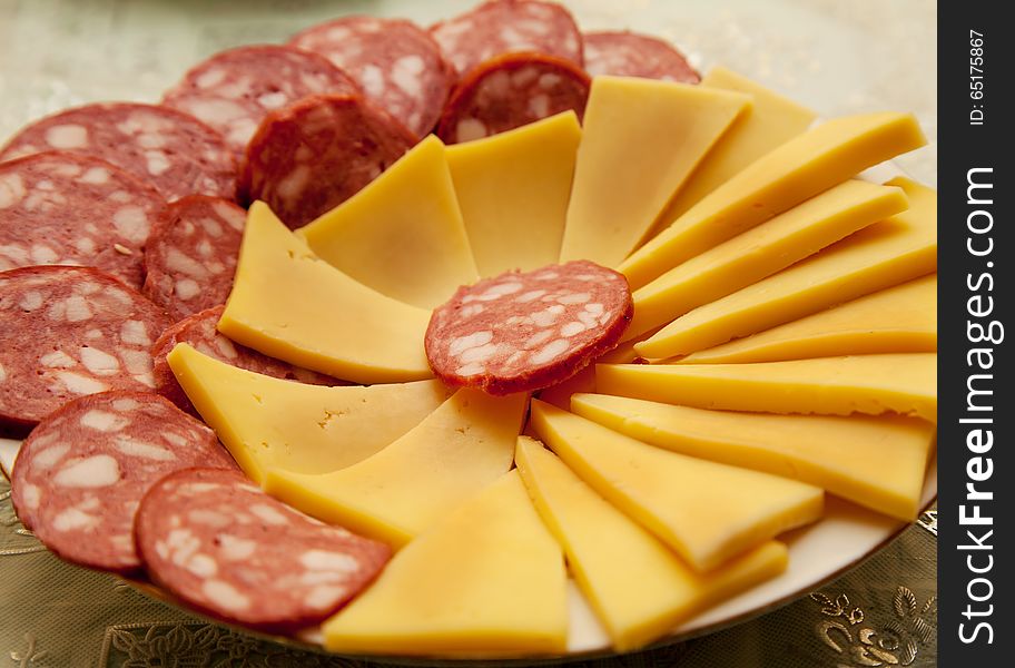 Slices of fresh sausage and cheese on a plate closeup. Slices of fresh sausage and cheese on a plate closeup