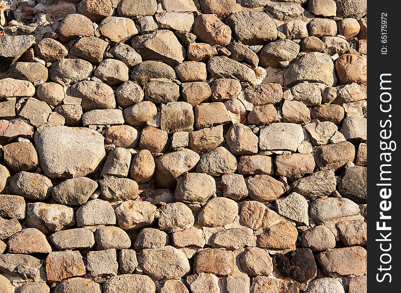 Vintage wall of large stones on sunny day closeup