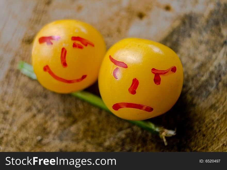Couple of yellow plums with human faces in backyard