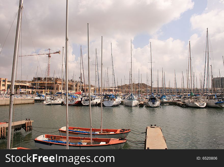 Port with sailboat and yachts in cloudy day