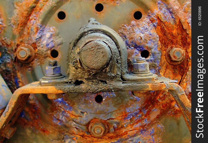 A rusty piece of metal equipment from an unknown machine. A rusty piece of metal equipment from an unknown machine