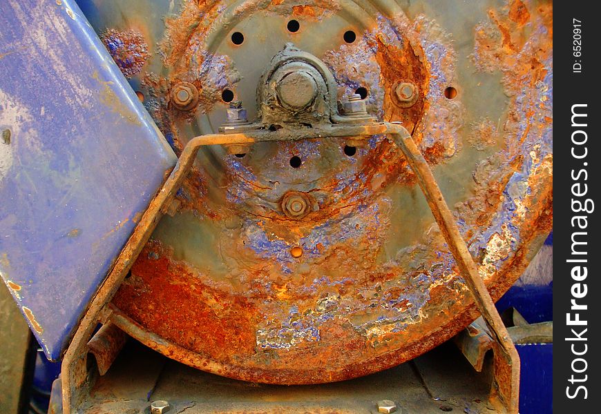 A rusty piece of metal equipment from an unknown machine. A rusty piece of metal equipment from an unknown machine