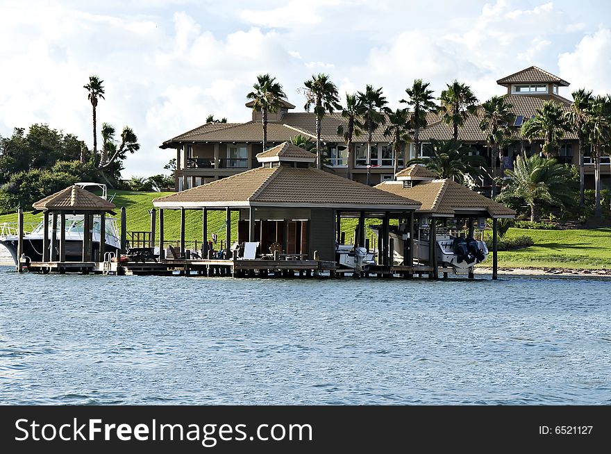 Beautiful tropical home surrounded by water, tropical plants, and two boat houses. Beautiful tropical home surrounded by water, tropical plants, and two boat houses.