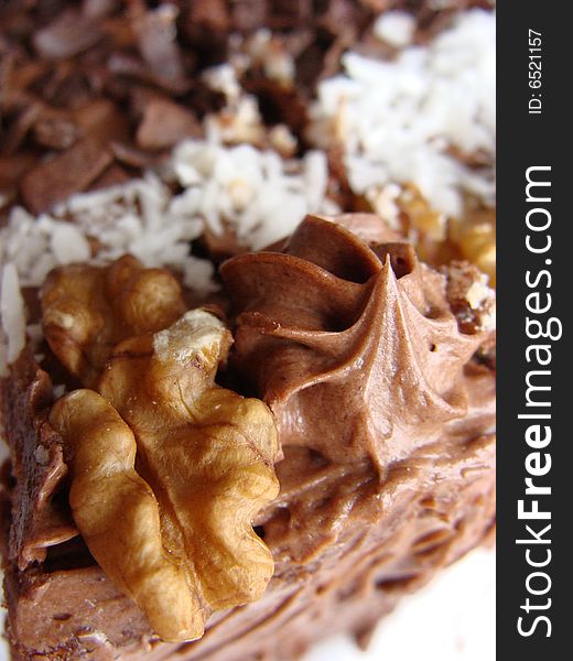 Chocolate cake covered with dried coconut, walnuts and coating glaze
