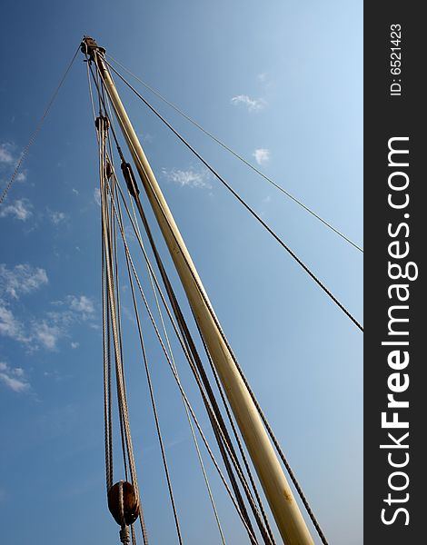 Wooden mast with blue sky in background