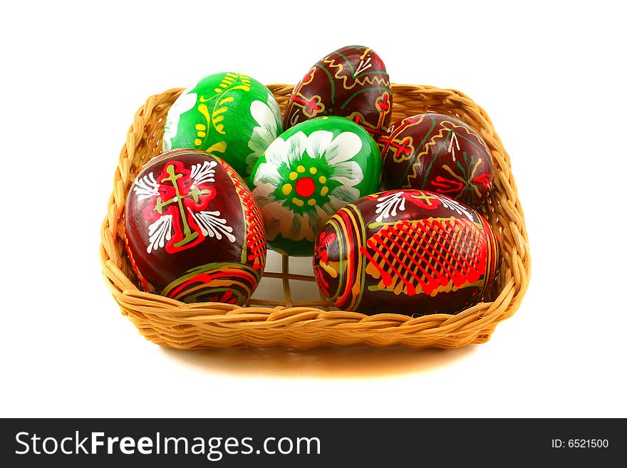 Six Easter eggs in a basket on a white background