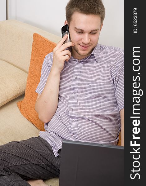 Casual guy sitting on sofa with laptop. Casual guy sitting on sofa with laptop