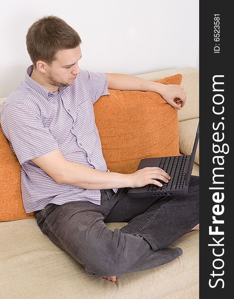Casual guy sitting on sofa with laptop. Casual guy sitting on sofa with laptop