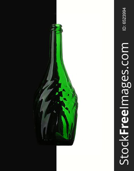Green bottle on the border of white and black. Green bottle on the border of white and black.