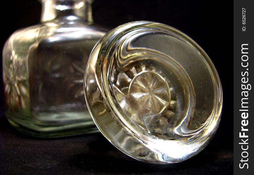 An old fashioned glass bottle on a black background