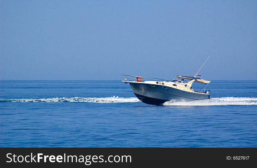 Photo of small fast cutter gliding at the sea surface