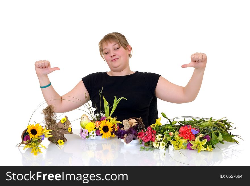 Young girl arranging flowers on reflective surface, white background, studio shot