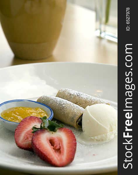 Blueberry spring rolls with strawberries mango preserves and vanilla ice cream