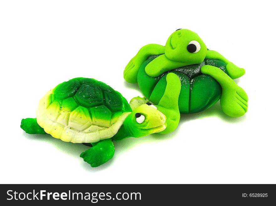 Two hand-made green turtles on a white background