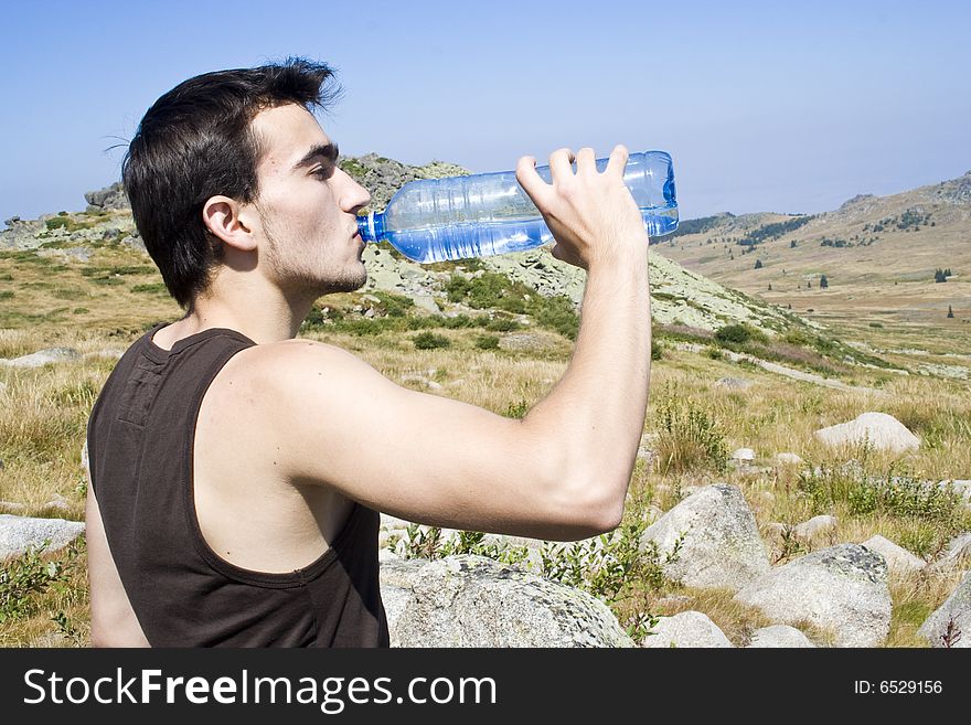 Boy drinking water in the mountain
