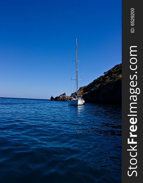 Sail yacht at anchor on the blue sky near Ponza island (Italy).