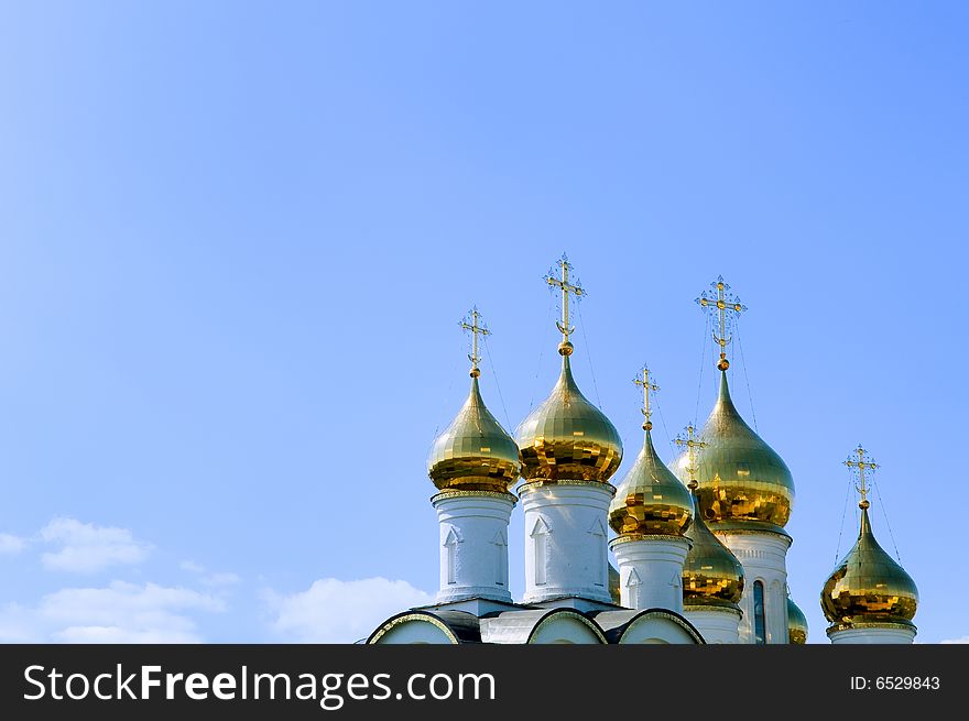 Golden church domes on blue sky background
