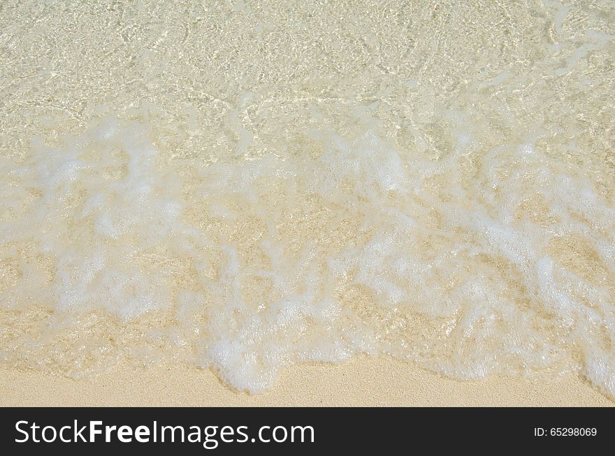 White foam made by ocean waves on sand