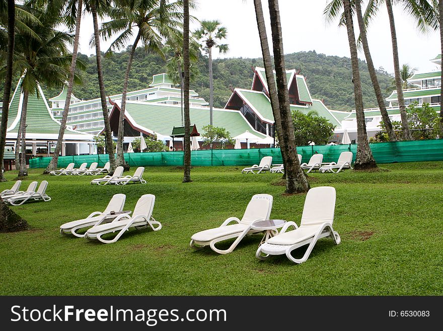 Deck chairs on the lawn at a tropical resort.