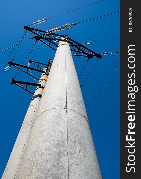 High voltage electric pillar against blue sky