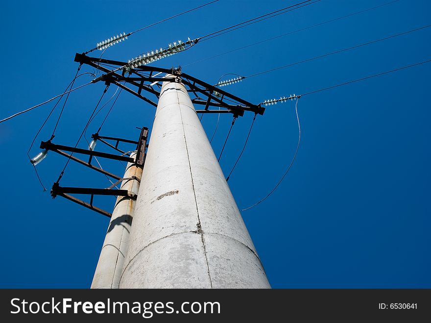 High voltage electric pillar against blue sky