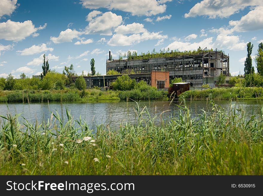 Abandoned chemical factory building with broken windows. Beautiful nature around it. Abandoned chemical factory building with broken windows. Beautiful nature around it.