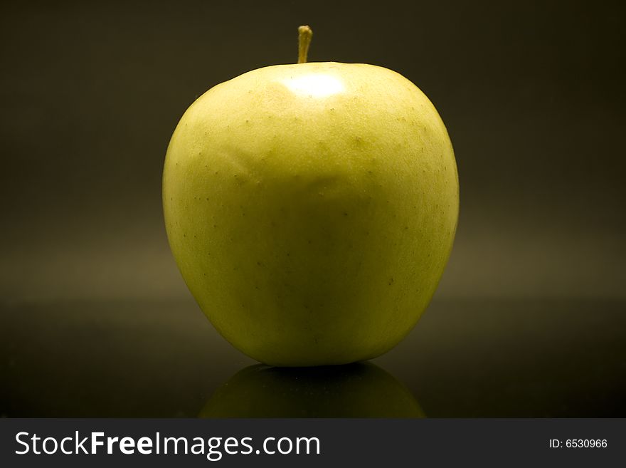 Yellow apple isolated on dark background