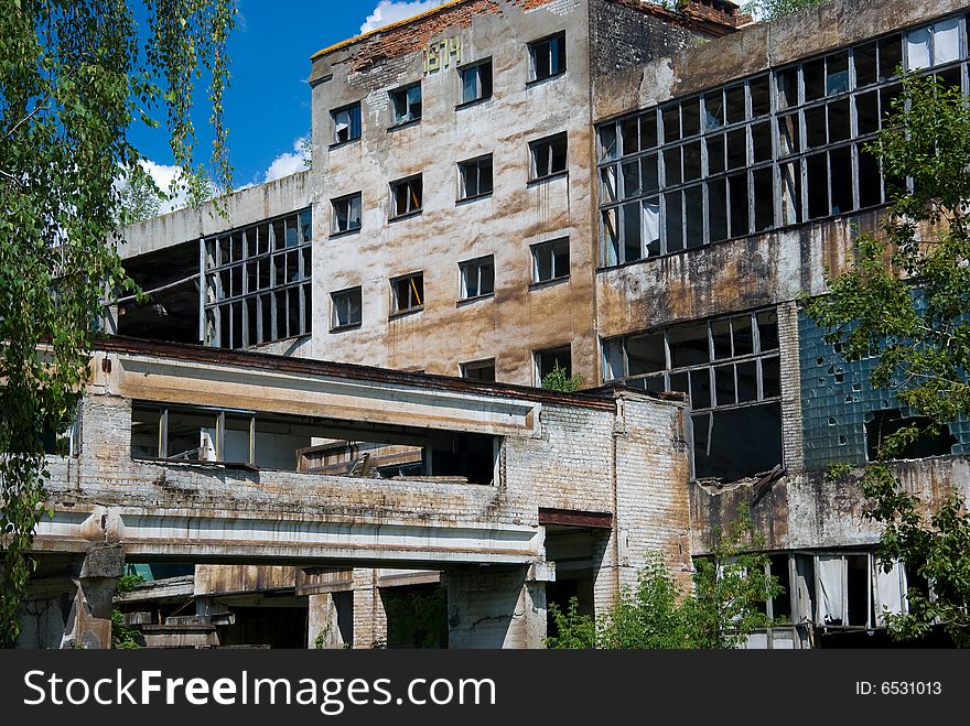 Abandoned chemical factory building with broken windows.